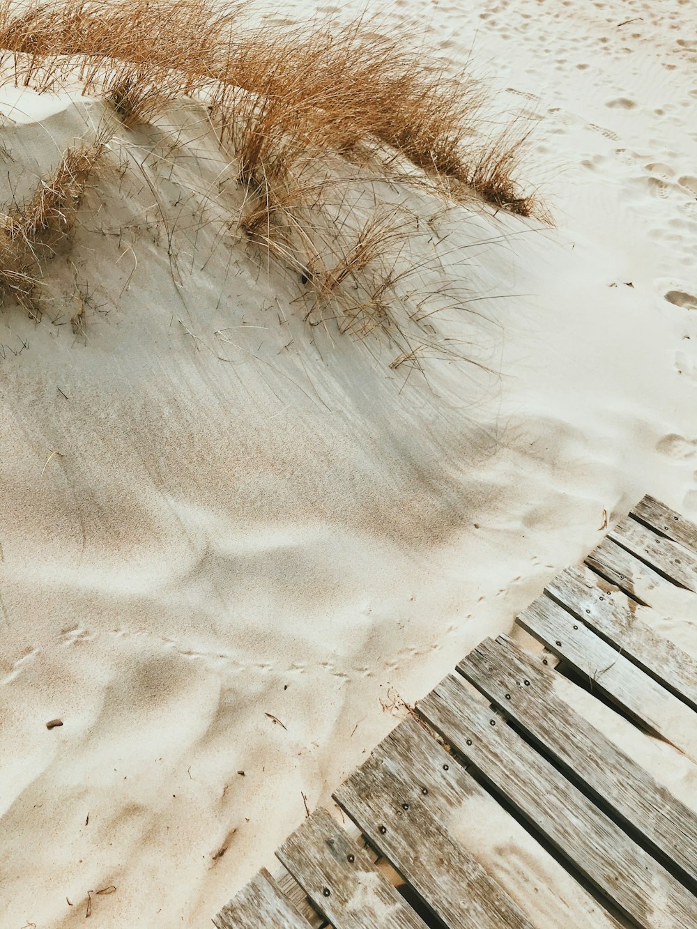 Brauner Holzzaun auf weißem Sand