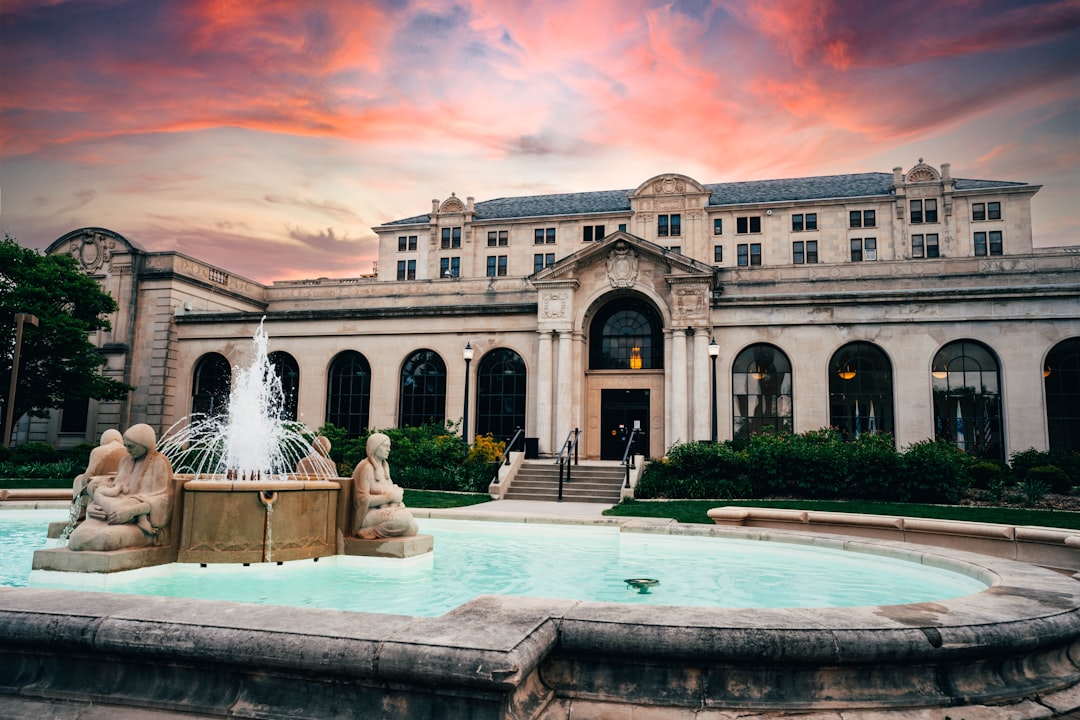 brown concrete building with fountain in front