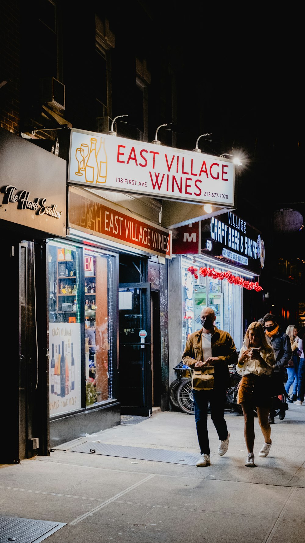 夜間に店の近くのベンチに座る人々