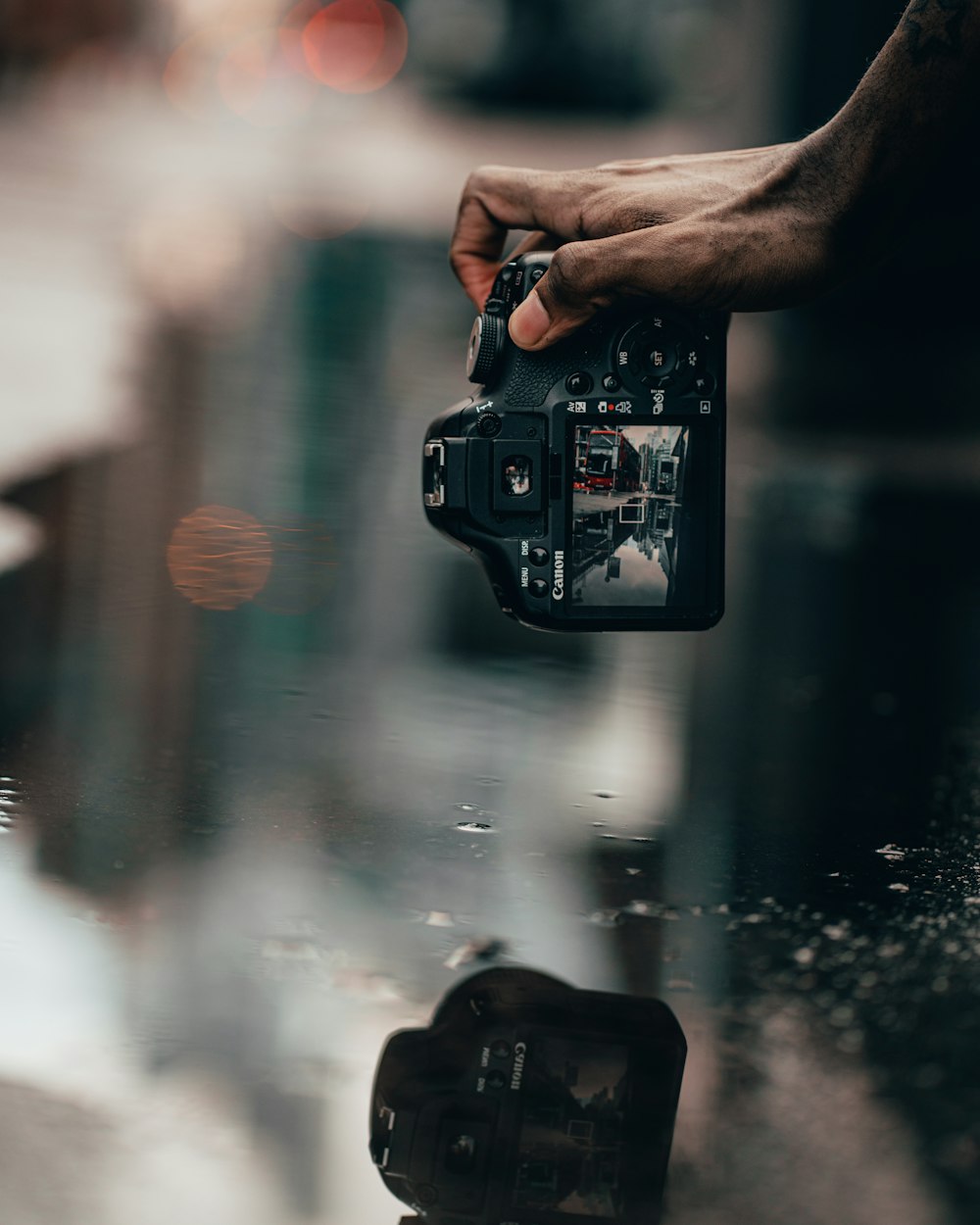 person taking photo of water droplets on glass