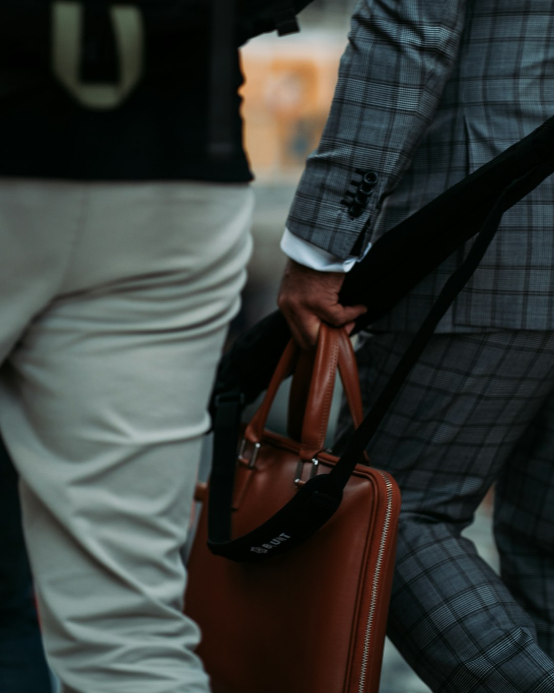 man in black and white plaid blazer and white pants