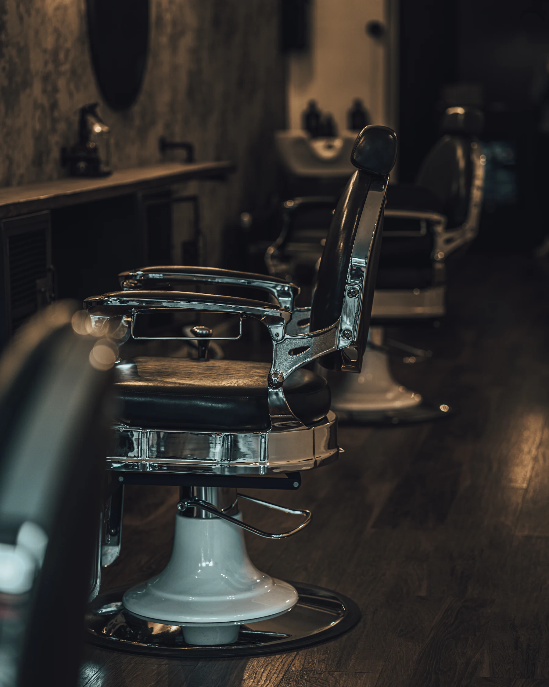 Vintage barber chairs lined up in a dimly lit shop