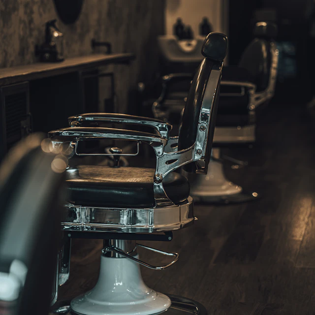 A black leather and silver metal barber chair