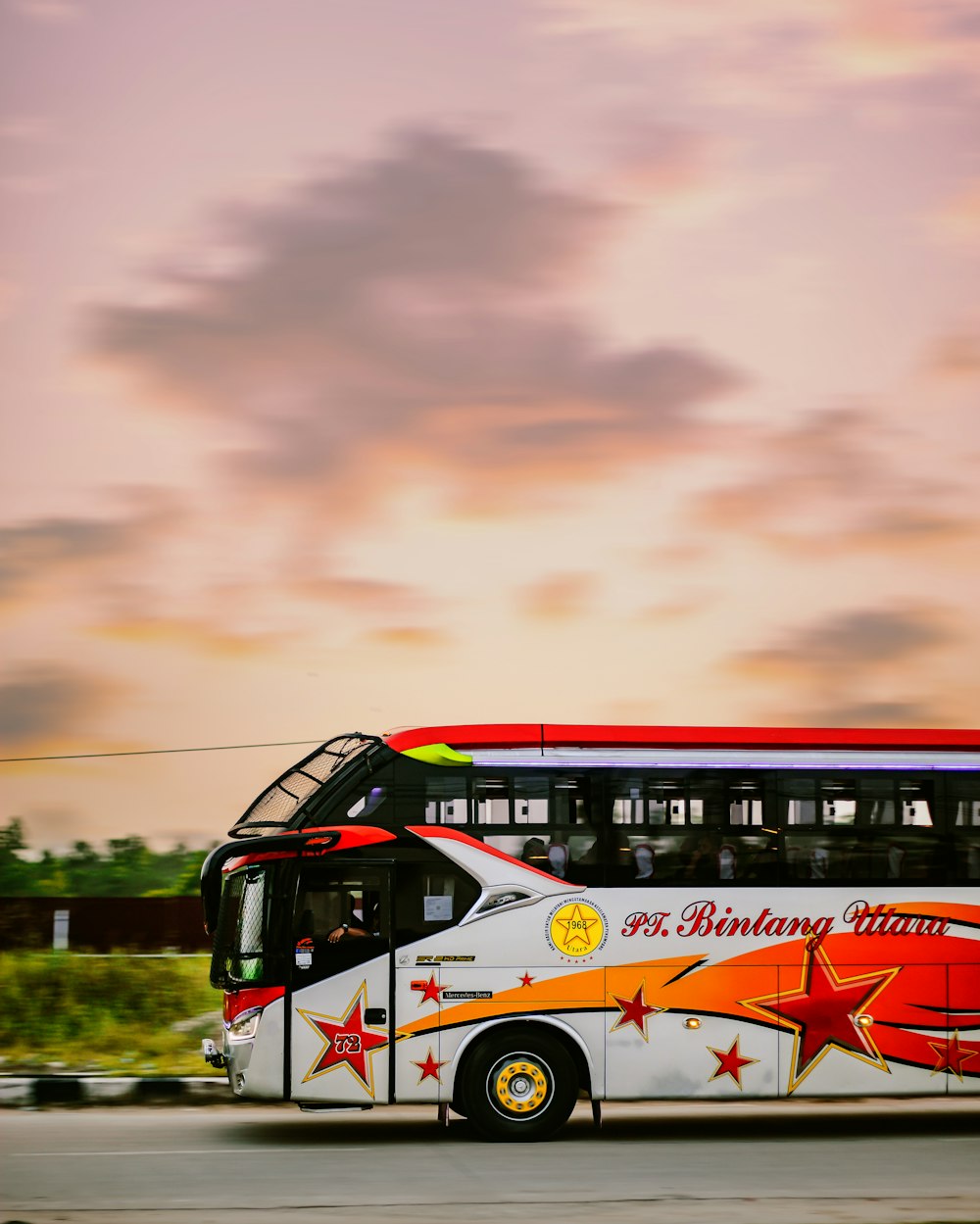 Weiß-roter Bus auf der Straße unter bewölktem Himmel