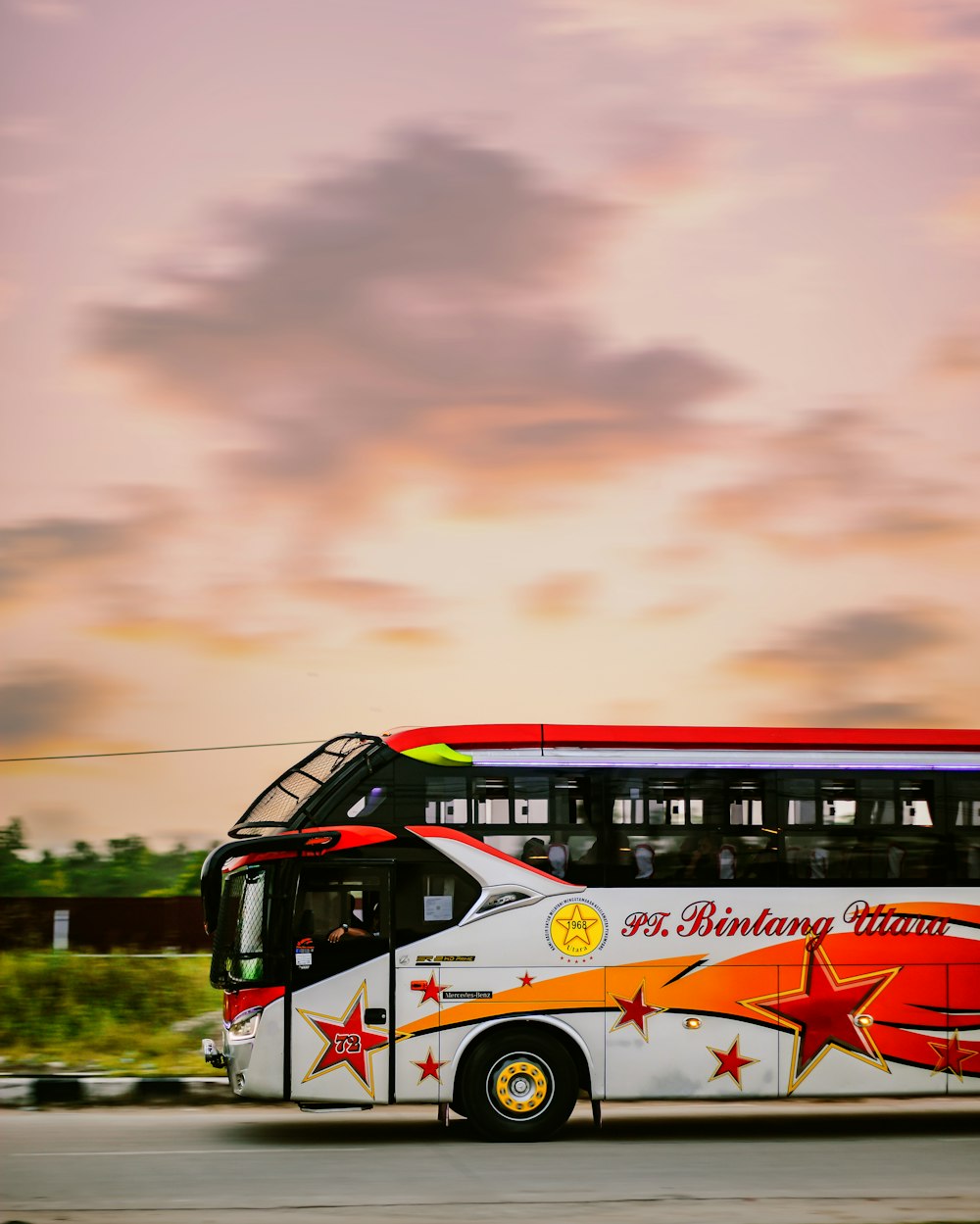 bus blanc et rouge sur la route sous un ciel nuageux