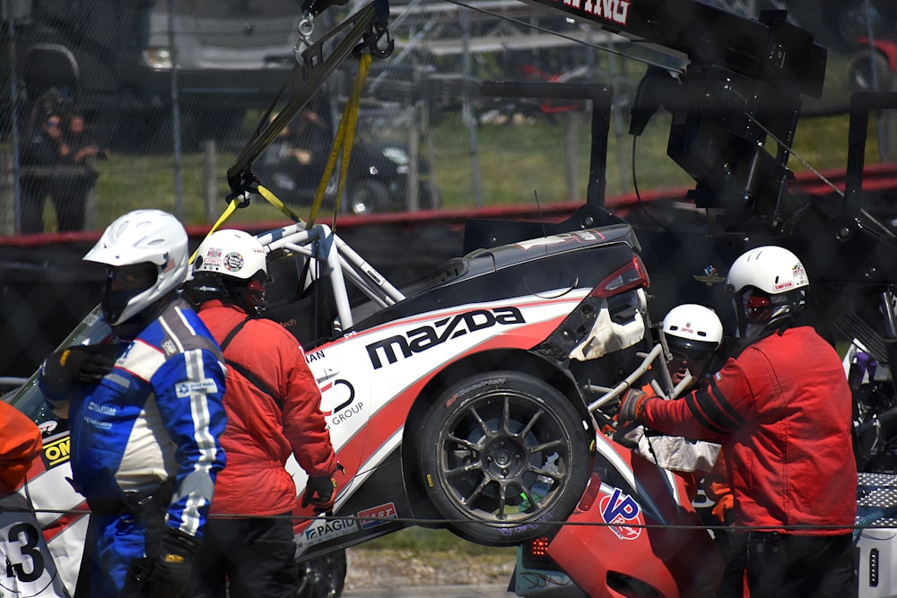 man in blue and red racing suit riding on red and white racing car