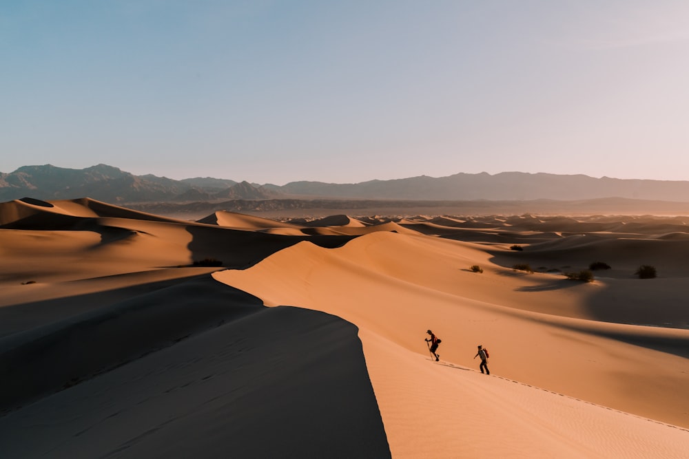 Gente caminando en el desierto durante el día