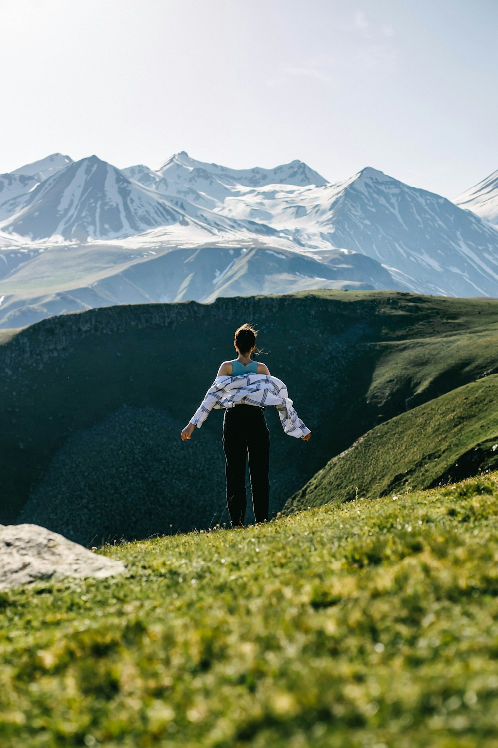 woman in white and black long sleeve shirt and black pants standing on green grass field