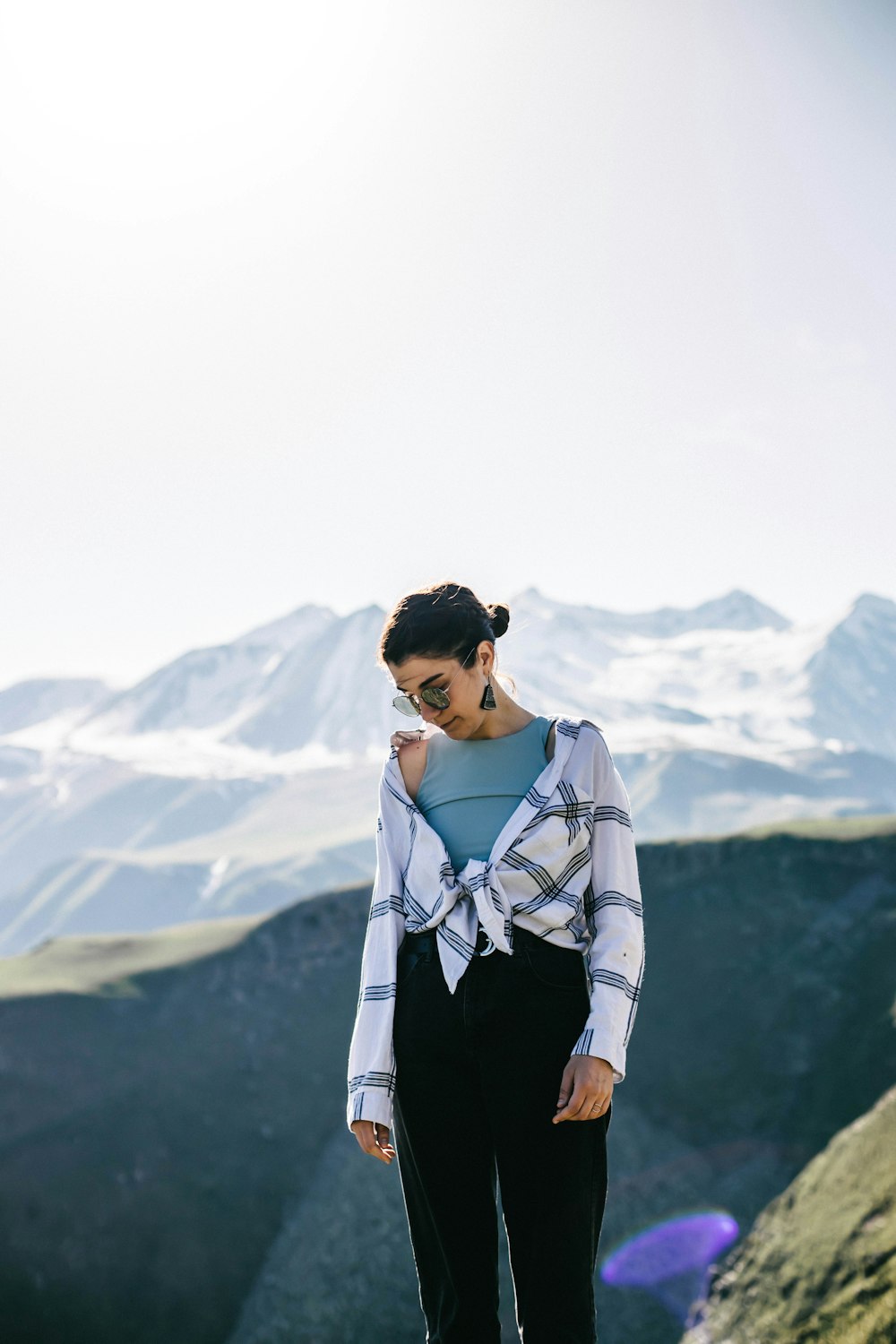 man in white long sleeve shirt and black pants standing on top of mountain during daytime