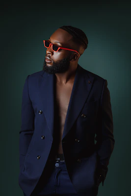 Stylish men's navy blazer displayed on a mannequin against a simple blue backdrop.