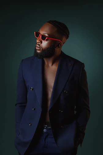 A stylish navy blue men's blazer displayed on a wooden hanger against a clean white background.