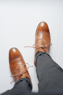 person wearing brown leather shoes