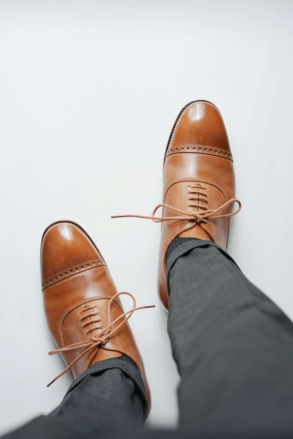 person wearing brown leather shoes