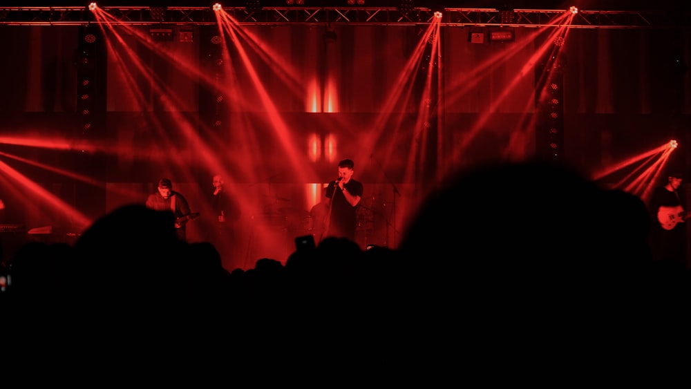 people standing on stage with red lights