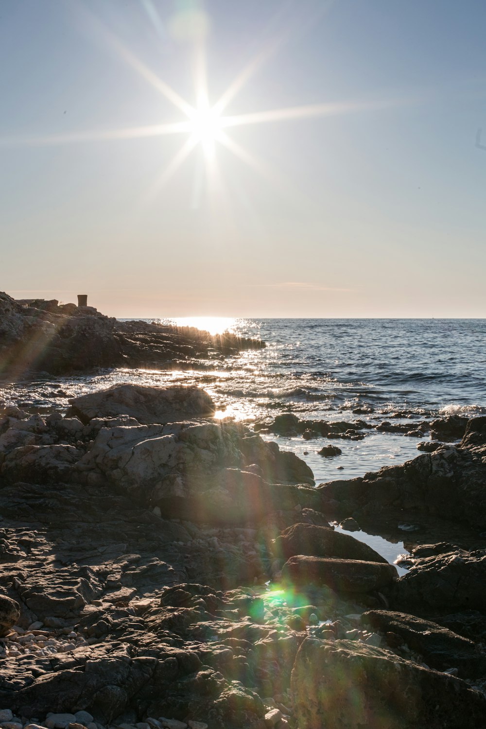 body of water near brown rock formation during daytime