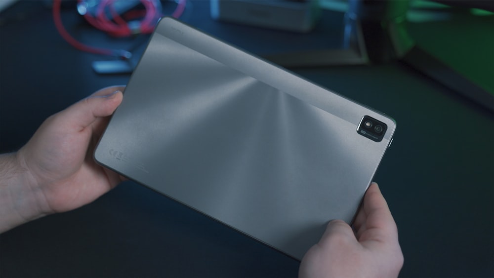 person holding gray tablet computer