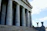 A hopeful person standing outside a courthouse, symbolizing justice regained.