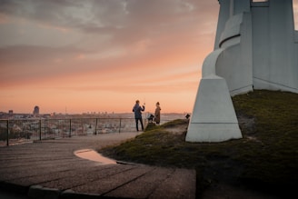 people standing on gray concrete pathway during sunset