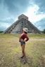 woman in brown jacket standing near pyramid during daytime