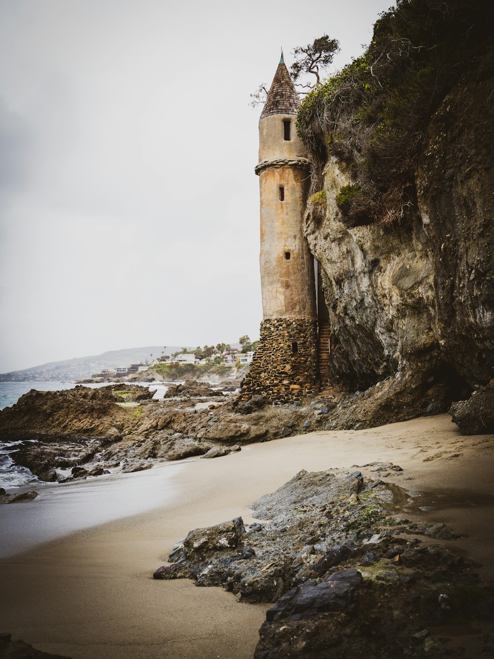 brown concrete building on brown sand near body of water during daytime