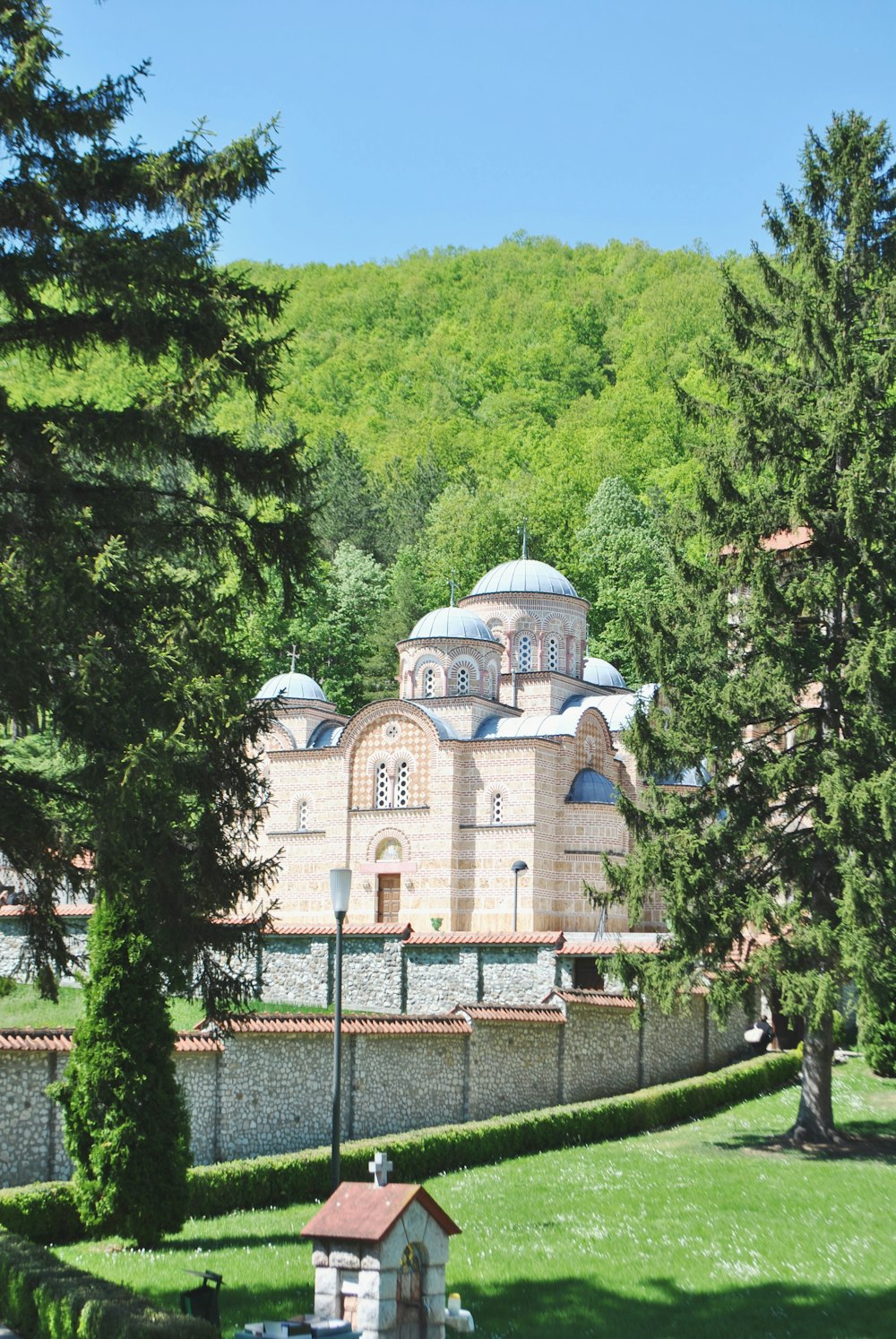 white and brown concrete building surrounded by green trees during daytime