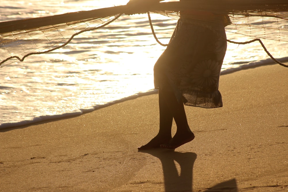 person in black pants standing on beach during daytime