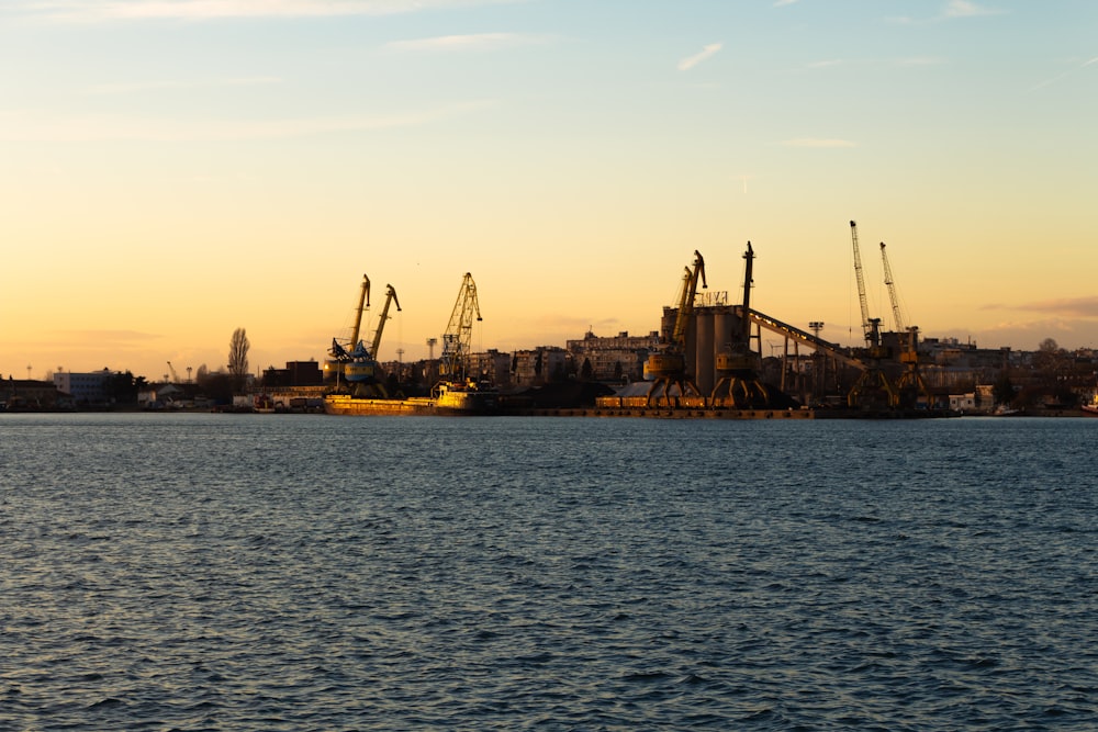 silhouette of buildings near body of water during sunset