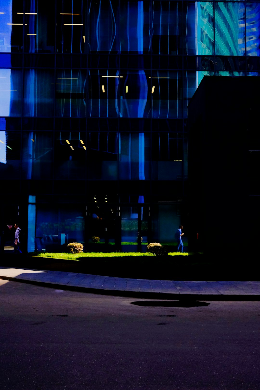 man in black jacket walking on sidewalk during nighttime