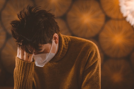 man in brown sweater wearing white face mask wanting to talk to someone from the 211 help line