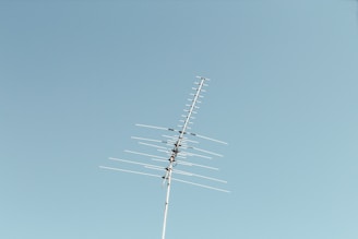 black electric post under blue sky during daytime