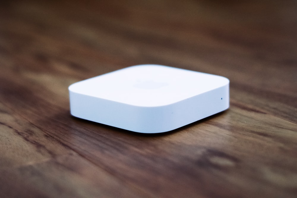 Apple TV blanco sobre mesa de madera marrón