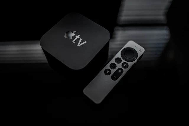 Dispositivo de televisión y mando sobre una superficie oscura