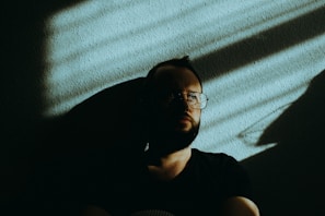 man in black crew neck t-shirt wearing black framed eyeglasses