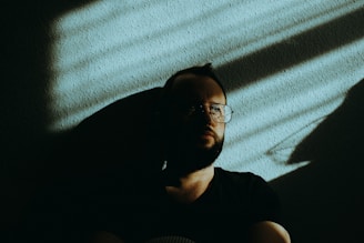 man in black crew neck t-shirt wearing black framed eyeglasses