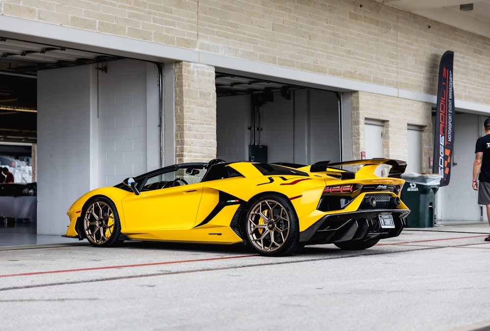 yellow lamborghini aventador parked in front of white building