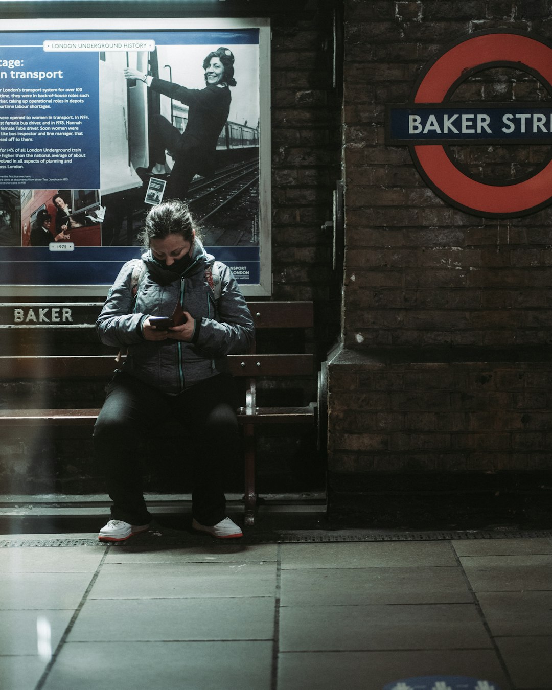 woman in black leather jacket sitting on black bench