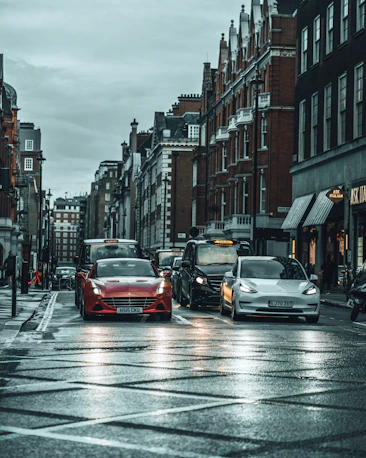 red car on road between high rise buildings during daytime