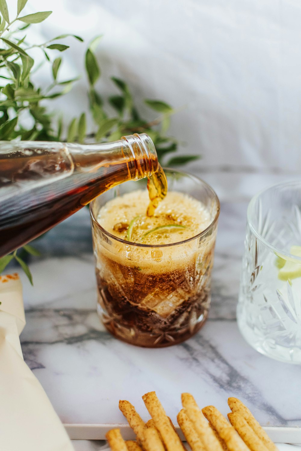 clear drinking glass with ice and brown liquid