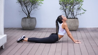 woman in white sports bra and black leggings doing yoga