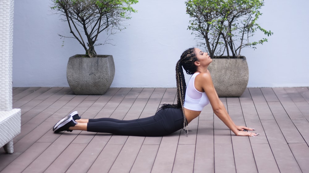 Frau in weißem Sport-BH und schwarzen Leggings beim Yoga