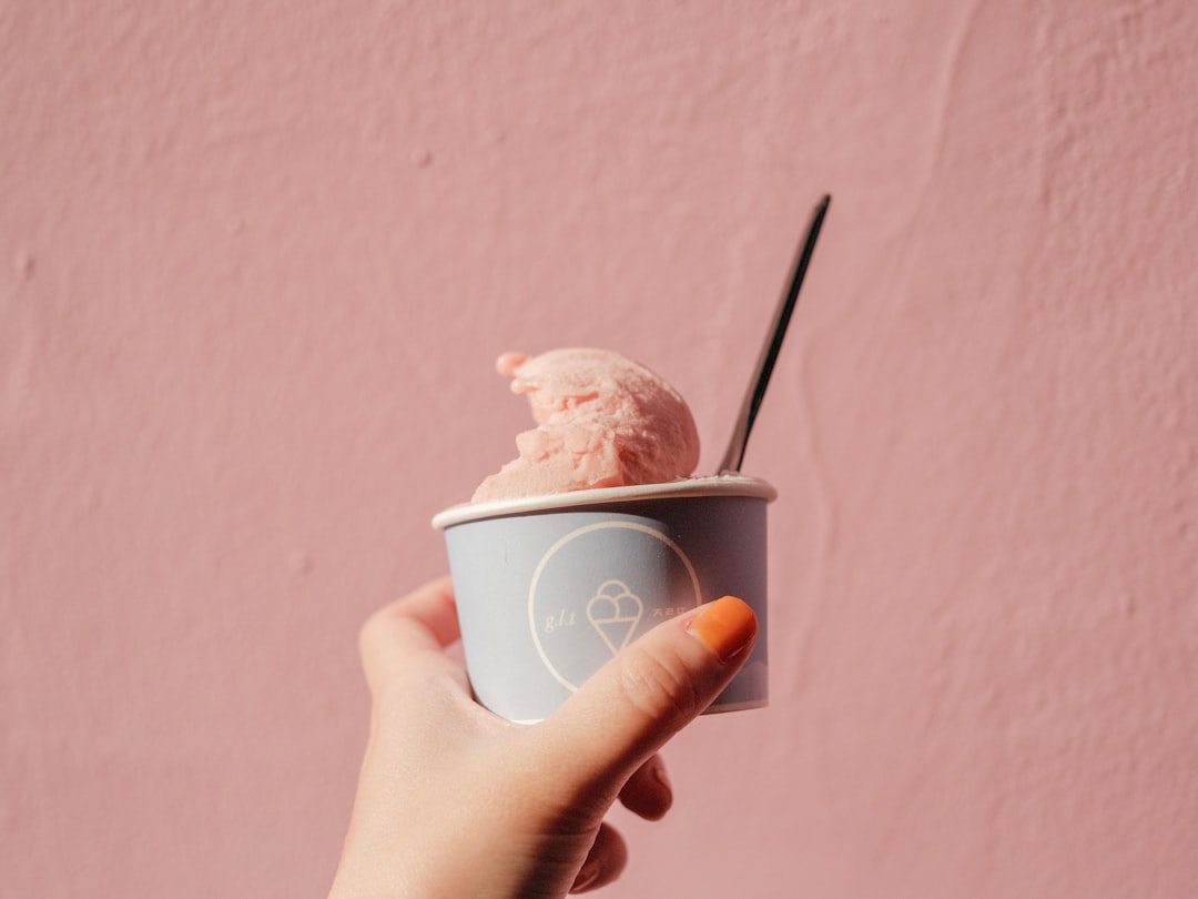 person holding white disposable cup with ice cream