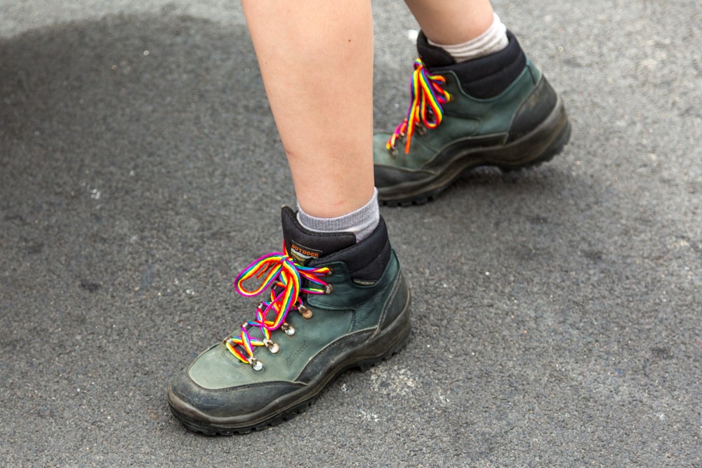 person wearing black and green nike athletic shoes