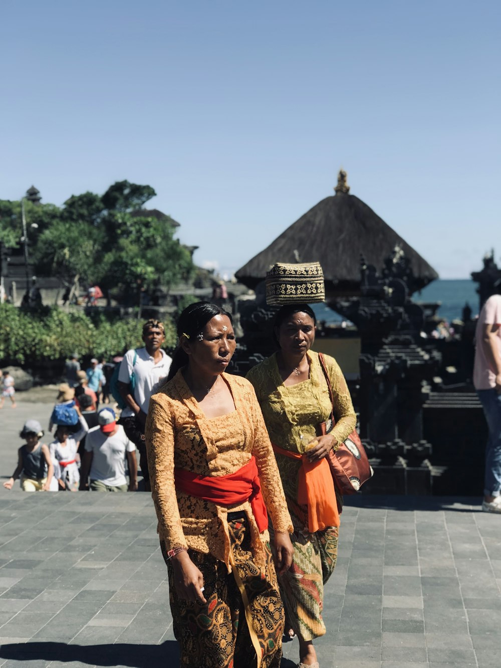 woman in red and gold sari standing on gray concrete floor during daytime