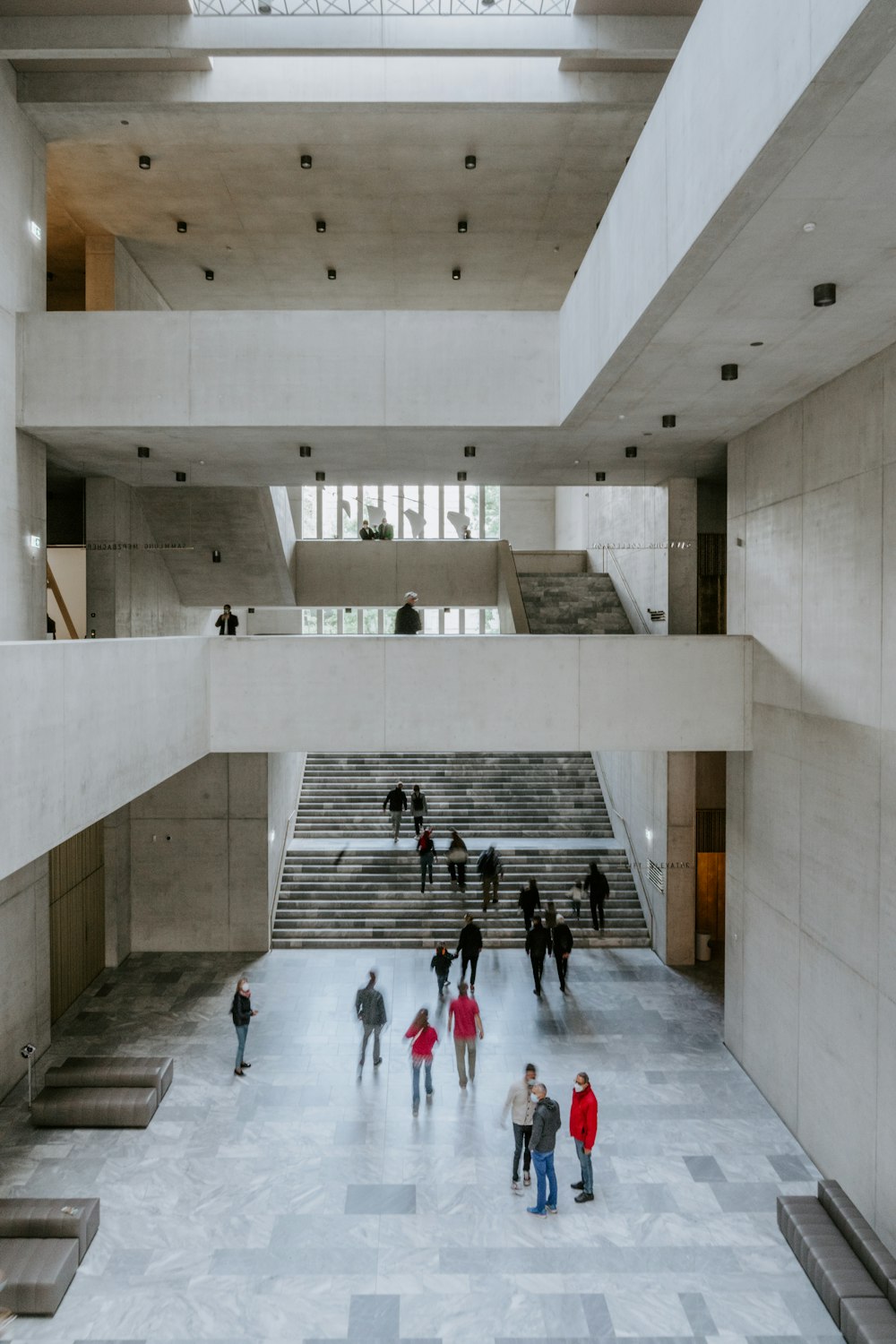 Gente caminando sobre un edificio de hormigón blanco