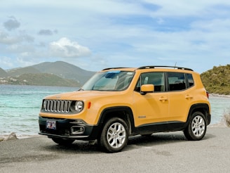 orange jeep suv on gray asphalt road during daytime