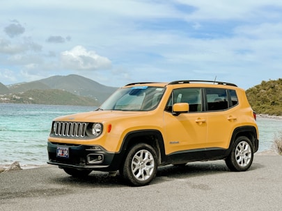 orange jeep suv on gray asphalt road during daytime