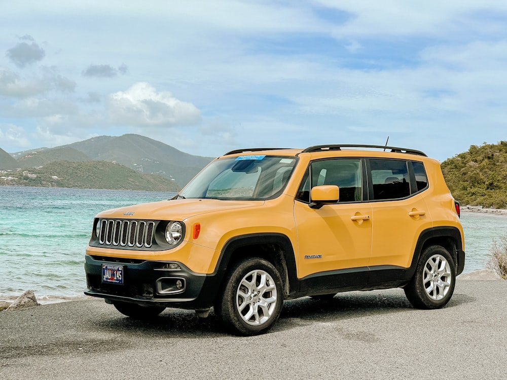 Orangefarbener Jeep-SUV tagsüber auf grauer Asphaltstraße