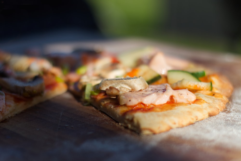 pizza with green vegetable on brown wooden table