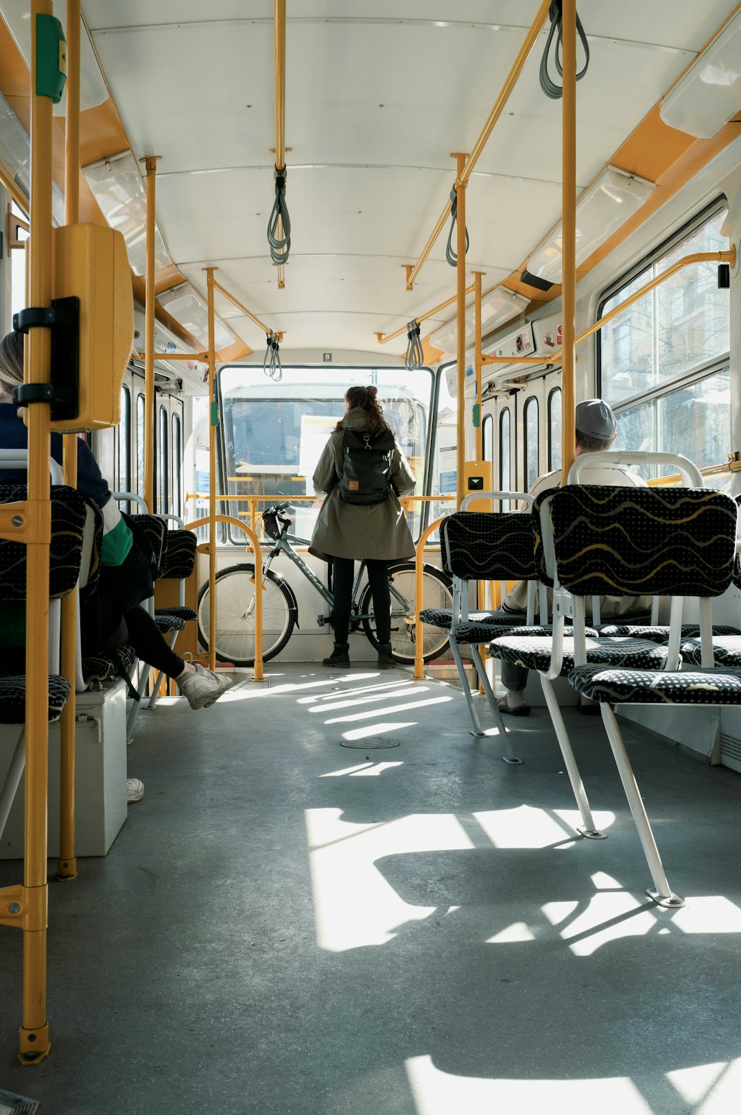 woman in black jacket standing beside yellow and black train