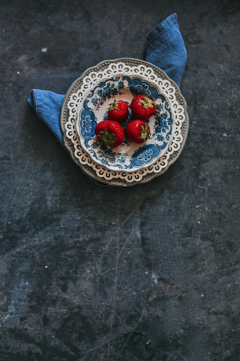 strawberries on blue and white floral ceramic bowl